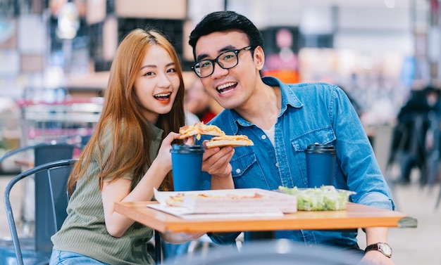 Young Asian couple having lunch together in cafe