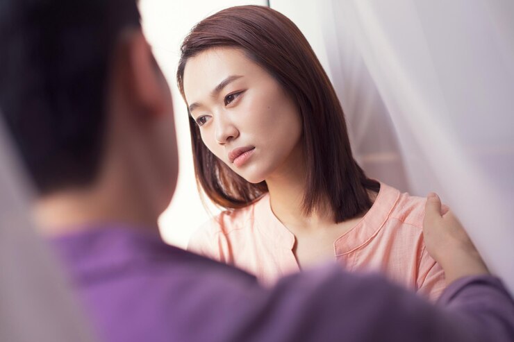 窓のそばで朝の若いアジア人カップル