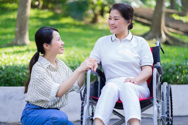 Young Asian daughter taking care of her disabled mother