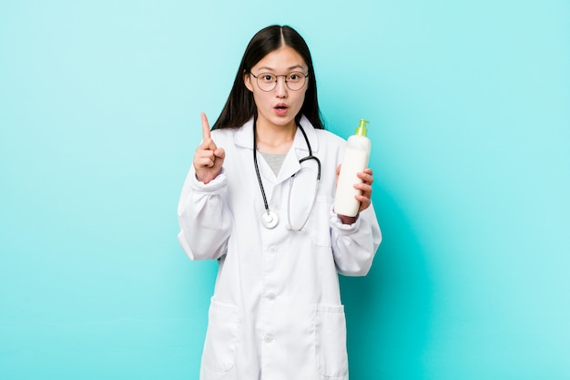 Молодая азиатская девушка дерматолога имея некоторую отличную идею, концепцию творческих способностей.