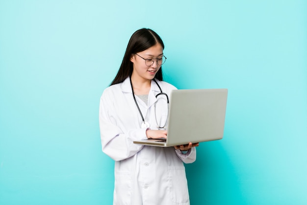 Young asian doctor woman holding a laptop