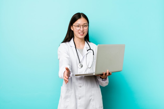 Young asian doctor woman holding a laptop