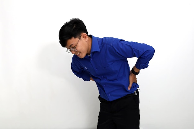 Young asian employee suffering from back pain isolated on white
background