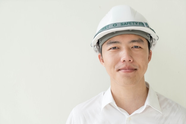 Young Asian engineer with white safety hard helmet 