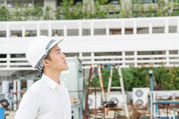 Young Asian engineer with white safety hard helmet 