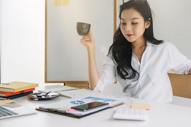 Young asian entrepreneur cogitating thinking making important decision at workplace.