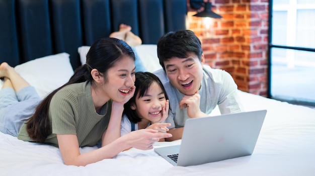 Young Asian family on the bed