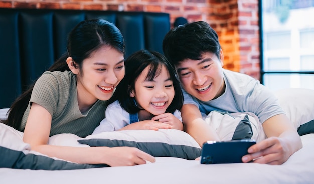 Young Asian family on the bed