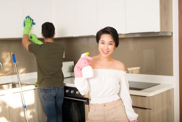 Young Asian family couple doing cleaning in the kitchen