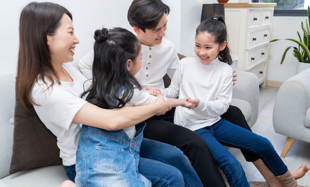 Young Asian family entertained at home in free time