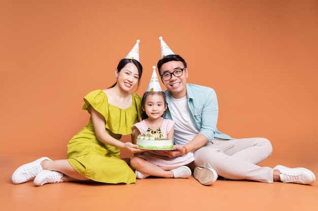 Young Asian family posing on background