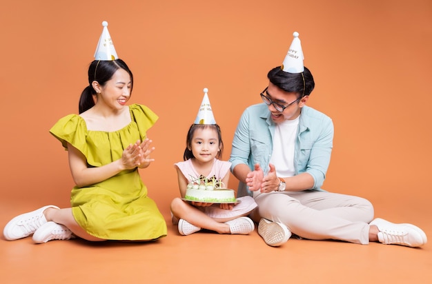 Young Asian family posing on background