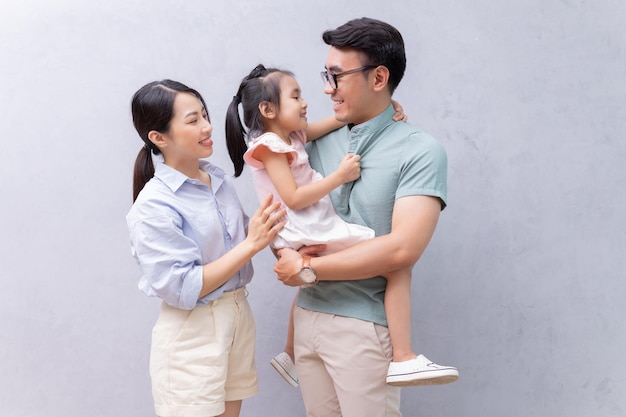 Young Asian family standing on background