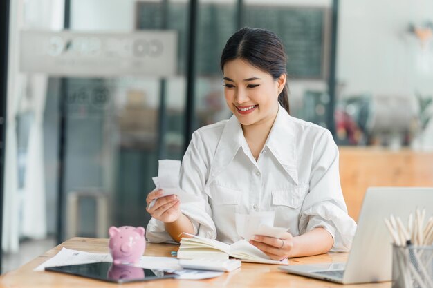 Photo young asian female accountant engages in financial planning with documents for budgeting savings and bill payments