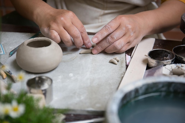 Young Asian Female focusing on her job at the pottery workshop