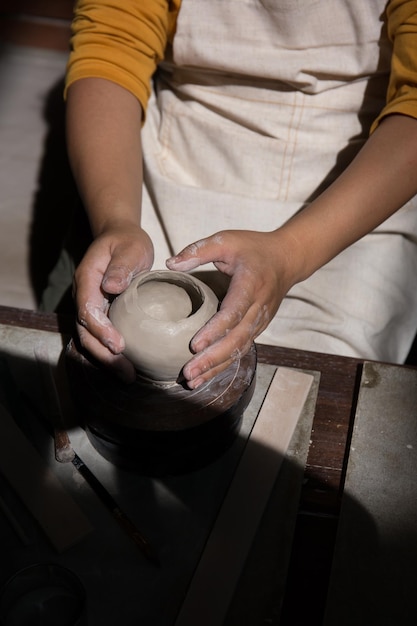 Young Asian Female focusing on her job at the pottery workshop