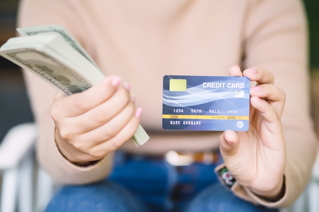 Foto la giovane femmina asiatica sta decidendo fra il pagamento con la carta di credito o incassa la caffetteria