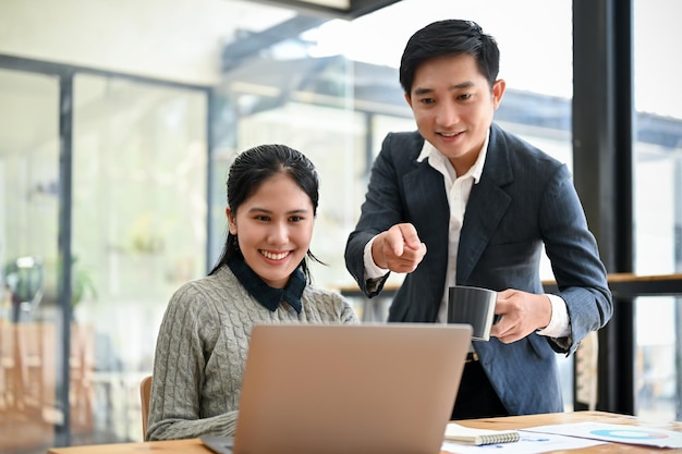 A young Asian female marketing assistant working on a new project with her boss