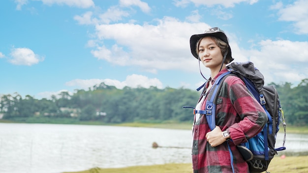 若いアジアの女性は流行に敏感なハイキングの準備をします