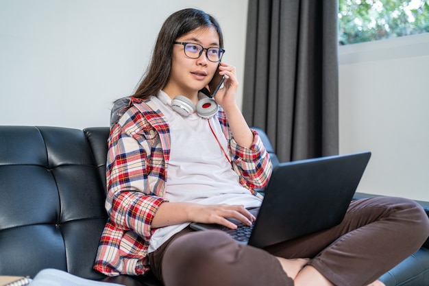 Young Asian female student working and studying from home during the city lockdown due to the spreading of corona virus