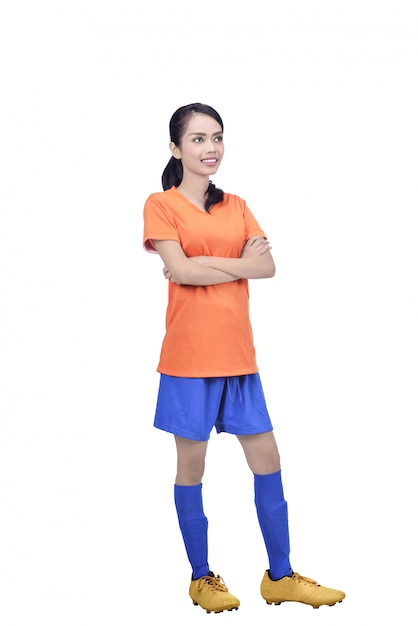 Young asian football player in orange jersey standing