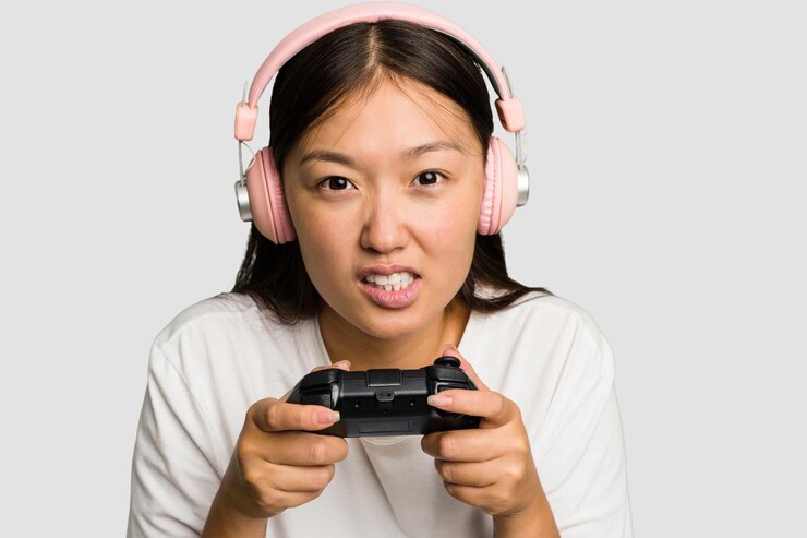 Photo アジアの若いゲーマー女性がゲームコントローラーとヘッドフォンで遊んでいます