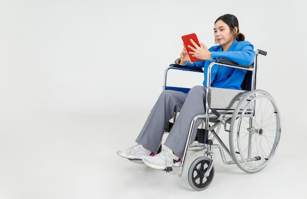 Young Asian girl as disability patient on hospital wheelchair study clinical report by reading physical health care and medical rehabilitation instruction for transporting injured or ill person.