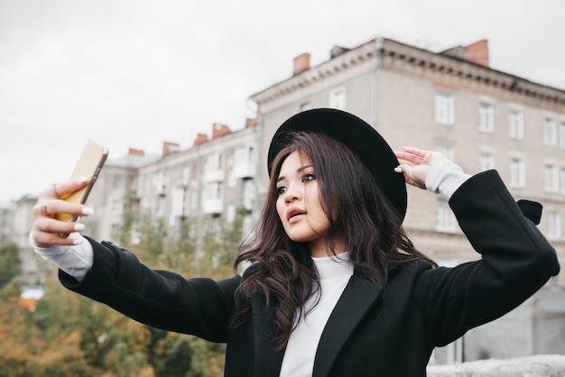 Young asian girl in dark coat and hat