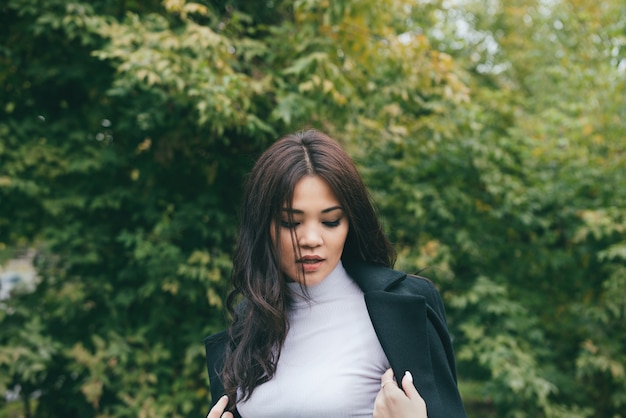 Young asian girl in dark coat