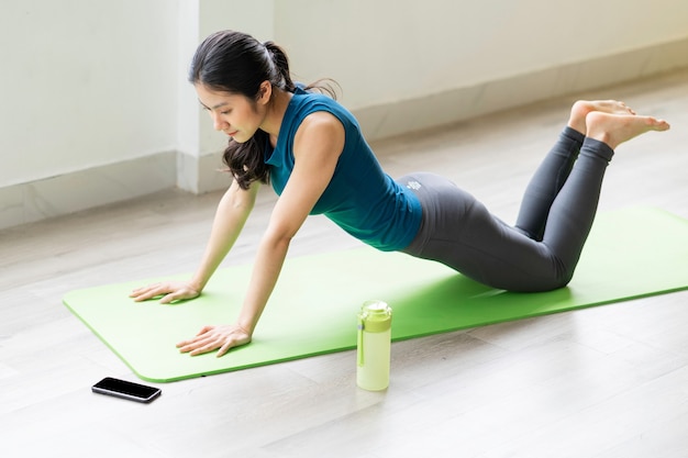 Young asian girl doing exercise on the floor alone