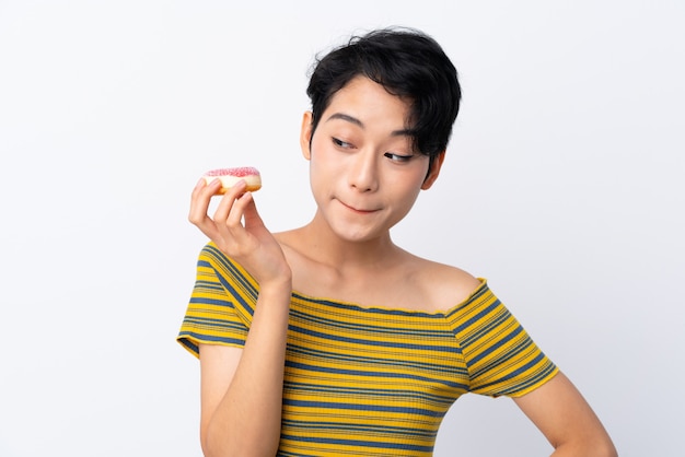 Giovane ragazza asiatica che tiene una ciambella