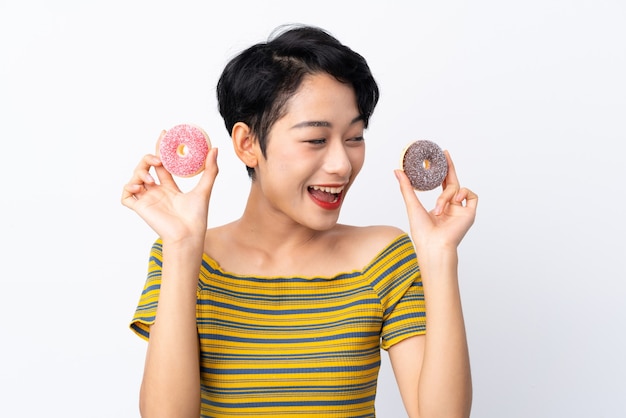 Young Asian girl holding donuts and surprised