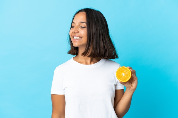 Young asian girl holding an orange isolated