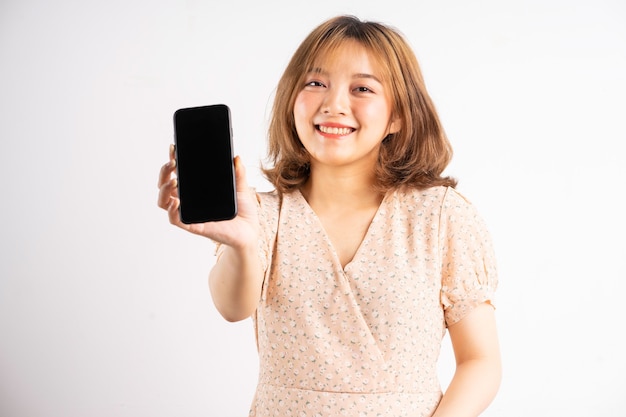 Young asian girl holding phone with expressions and gestures on white