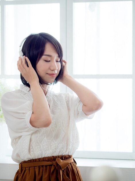 Young asian girl listening to the music at home