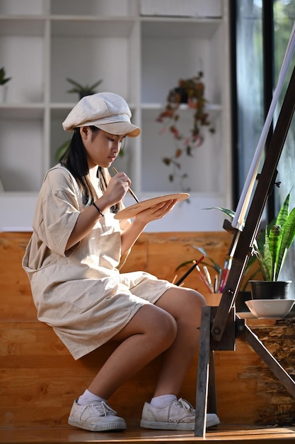 Photo young asian girl painting picture in art class.