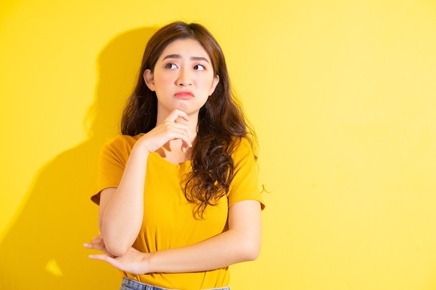 Young asian girl posing on yellow