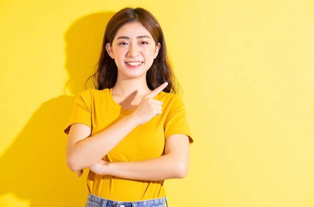 黄色でポーズをとる若いアジアの女の子