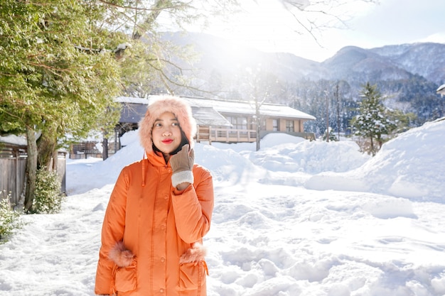 Молодая азиатская девушка на снеге на Shirakawa-идет, Япония.