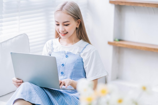 Young Asian girl using laptop at home