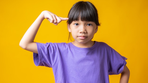 Giovane ragazza asiatica in maglietta viola pensando e indicando la testa per avere un'idea,