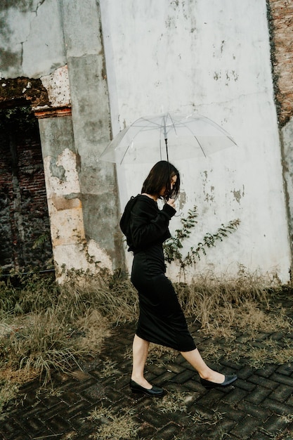 Foto giovane ragazza asiatica che cammina in un vestito nero