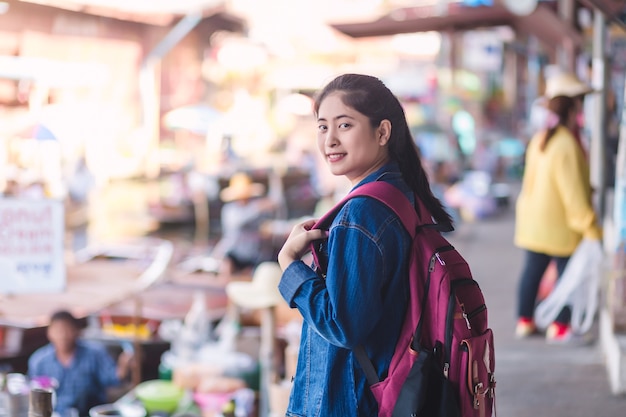 Photo young asian girl walking at dumonoe saduak floating market, in thailand