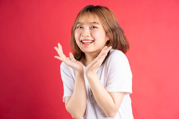 Young asian girl with cheerful gestures and expressions on pink