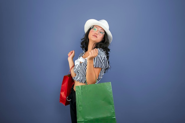 Young asian girl with shopping bags and hat