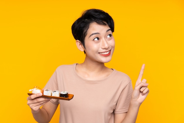 Young Asian girl with sushi intending to realizes the solution while lifting a finger up