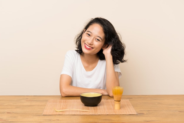 お茶抹茶を持つ若いアジアの女の子