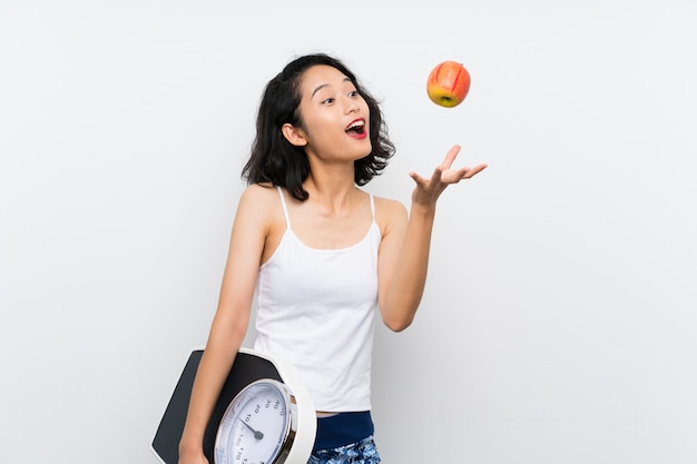 Young asian girl with weighing machine 