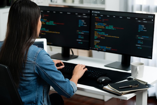 Young Asian in IT creating with typing online information on pc Stratagem
