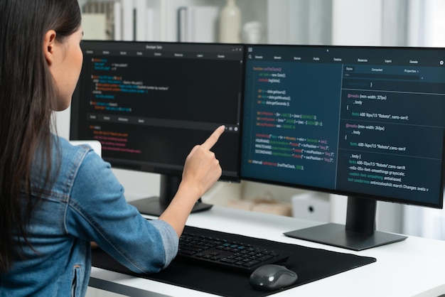 Young asian in it developer pointing online information on pc stratagem